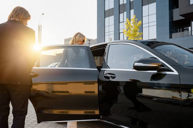 A private chauffeur opening the door of a premium vehicle for a guest